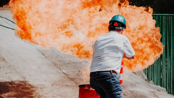 Photo by Shalom de León man in white shirt and blue denim jeans wearing black helmet standing on gray concrete road