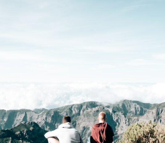 스트레스 해소를 위한 신체 활동의 중요성 a couple of people sitting on top of a mountain
