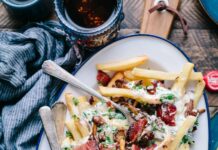 운동 전후로 먹으면 좋은 음식과 피해야 할 음식 bacon strips and melted cheese topped fries on oval white and blue platter with gray stainless steel forks