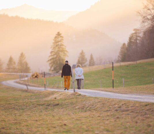 운동과 야외 활동으로 건강 지키기 woman in black jacket and white pants walking on road during daytime