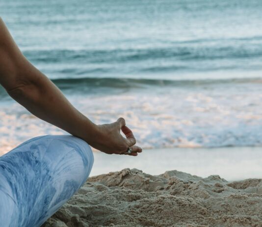 스트레스를 감소시키는 명상의 효과 person in blue shorts sitting on beach shore during daytime