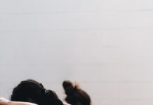 하루 10분, 필라테스로 허리 통증 잡는다 woman in black tank top and black leggings lying on black floor