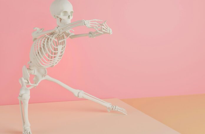 a skeleton is dancing on a pink background