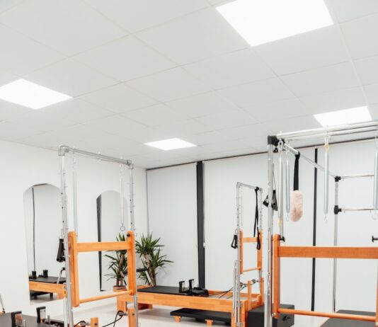 30~40대 여성을 위한 필라테스 a white room with mirrors and equipment in it