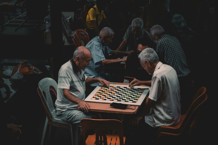 Photo by Kush Dwivedi a group of older men playing a game of chess