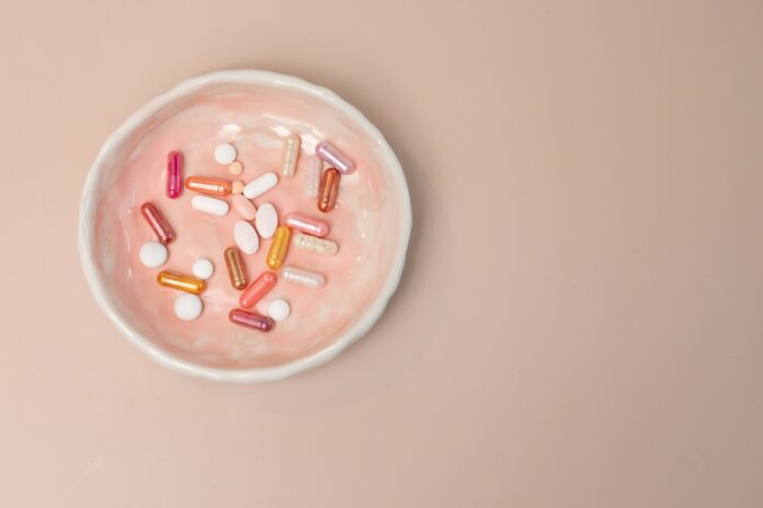 A white bowl filled with pills on top of a table