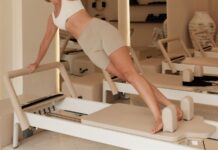 부기 제로: 림프 순환을 도와 아침 저녁 부기를 제거하는 루틴 Woman does pilates on a machine in a studio.