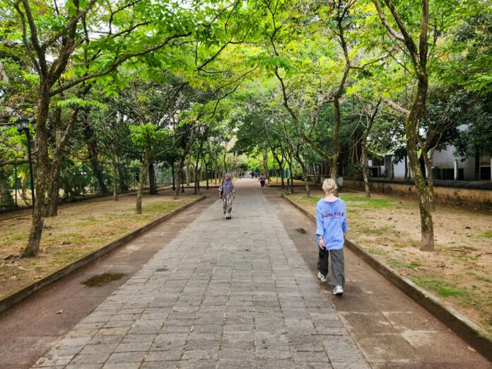 Photo by Zoshua Colah Two people walking down a path in a park