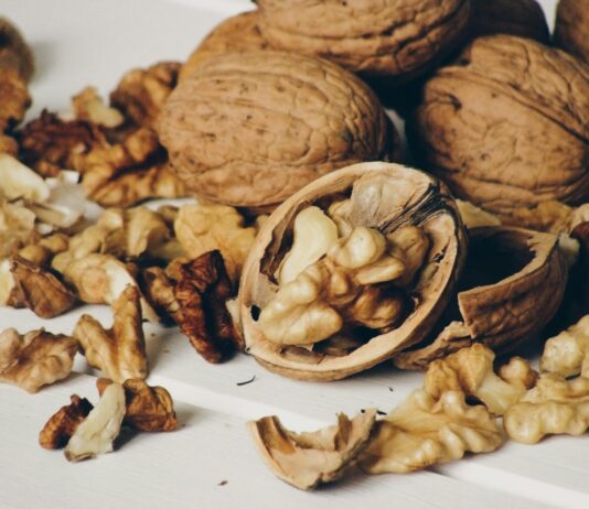 “뇌를 젊게, 마음을 건강하게: 일상 속 뇌건강을 위한 실천법” A pile of whole and shelled walnuts