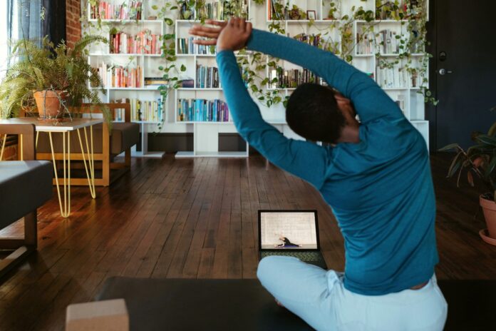 Photo by Windows a man doing yoga in a living room
