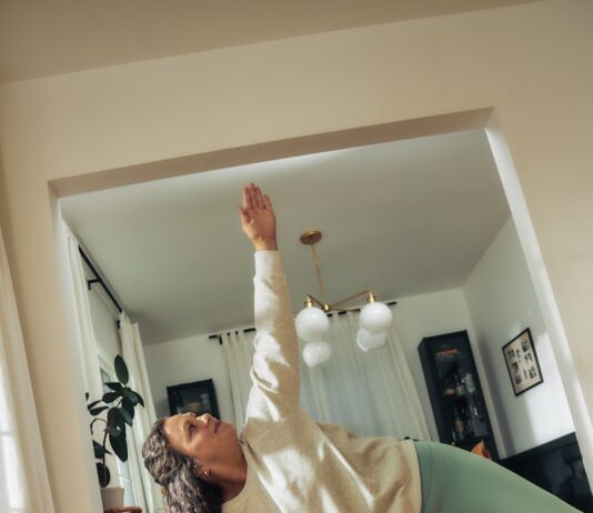 “정신건강 관리, 일상 속 작은 실천에서 시작하세요” A woman does a yoga pose on a mat.