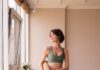집에서도 쉽게, 필라테스 열풍…일상 속 실천법 주목 a woman in a green sports bra top and leggings holding a yoga mat