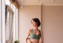 집에서도 쉽게, 필라테스 열풍…일상 속 실천법 주목 a woman in a green sports bra top and leggings holding a yoga mat