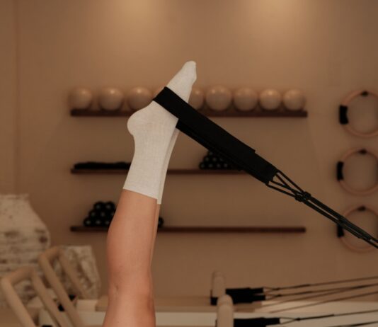 집에서도 전문 스튜디오 못지않게… 일상 속 필라테스로 건강 챙기기 바람 Woman does pilates exercise on a reformer machine.